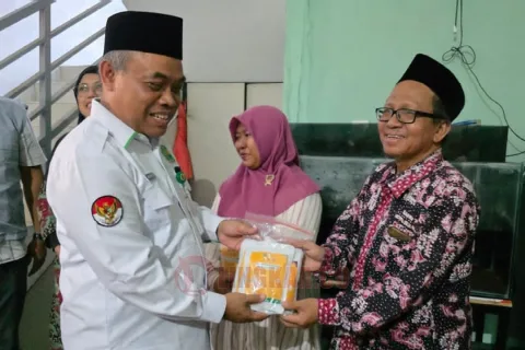 Kepala Kemenag Kota Semarang, Muhtasit beserta perwakilan Ditjen PHU Kemenag RI, dan BAZNAS RI serta perwakilan Baznas Kota Semarang menyerahkan dan haji 2025 kepada salah satu penerima. Foto: dokumentasi/istimewa