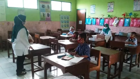 BERJARAK: Siswa-siswi SD 4 Cendono menjaga jarak saat hadir ke sekolah. (NISA HAFIZHOTUS SYARIFA/LINGKAR JATENG)
