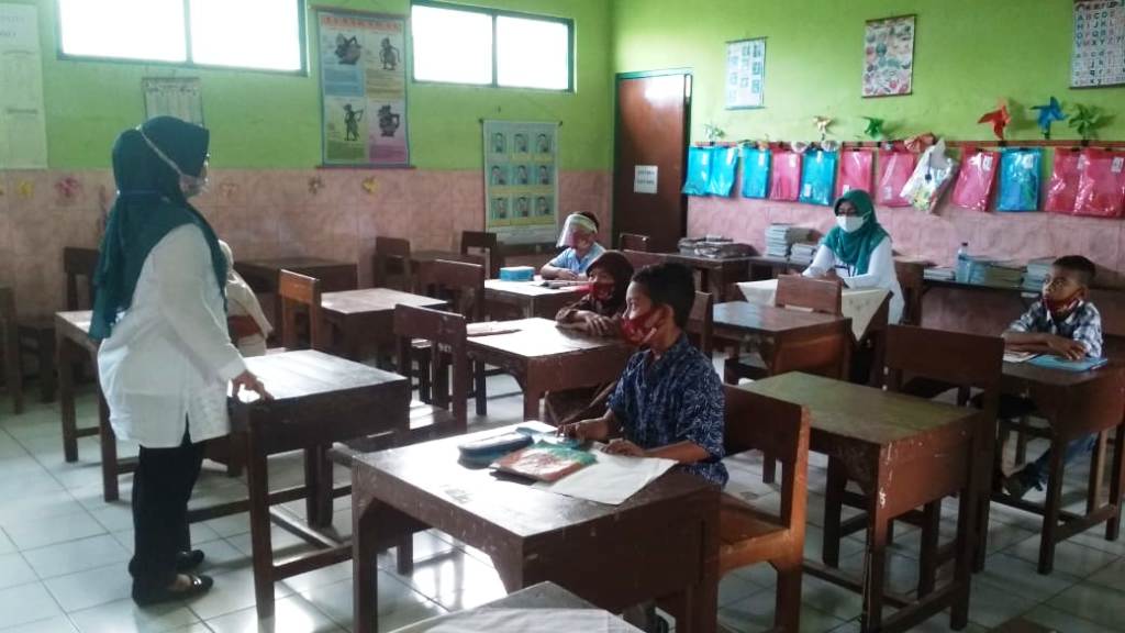 BERJARAK: Siswa-siswi SD 4 Cendono menjaga jarak saat hadir ke sekolah. (NISA HAFIZHOTUS SYARIFA/LINGKAR JATENG)