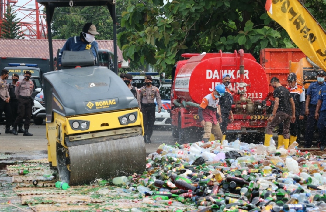 PEMUSNAHAN: Sebuah alat berat saat menggilas ribuan miras di halaman Mapolres Jepara, Senin (21/12). (DOK. LINGKAR JATENG)