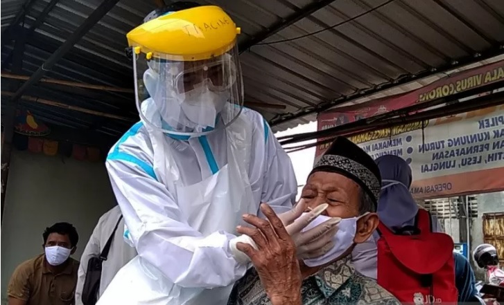 Seorang warga tampak kesakitan saat menjalani tes cepat (rapid test) antigen setelah terjaring razia karena tidak memakai masker di Pasar Mindahan, Kecamatan Batealit, Kabupaten Jepara, Jawa Tengah, Selasa (22/12). (ANTARA/LINGKAR.CO)