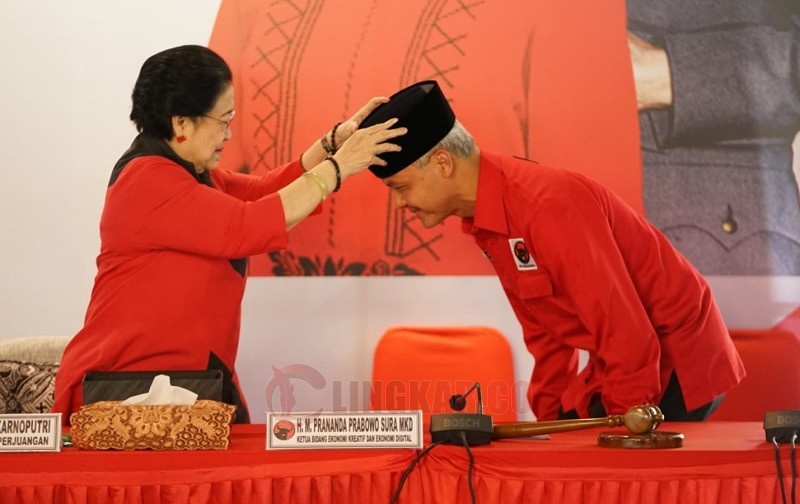Ketua Umum PDIP, Megawati Soekarnoputri, menyematkan peci hitam kepada Ganjar Pranowo, saat deklarasi capres, Jumat (21/4/2023). FOTO: Dok. PDIP