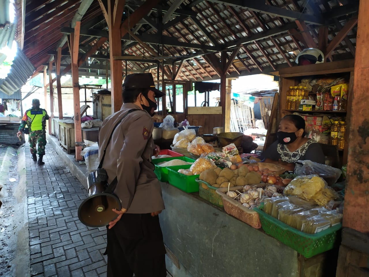PANTAU : Seorang anggota kepolisian saat memantau kondisi ketersediaan kebutuhan pokok di salah satu pasar tradisional. (ISTIMEWA / LINGKAR JATENG)