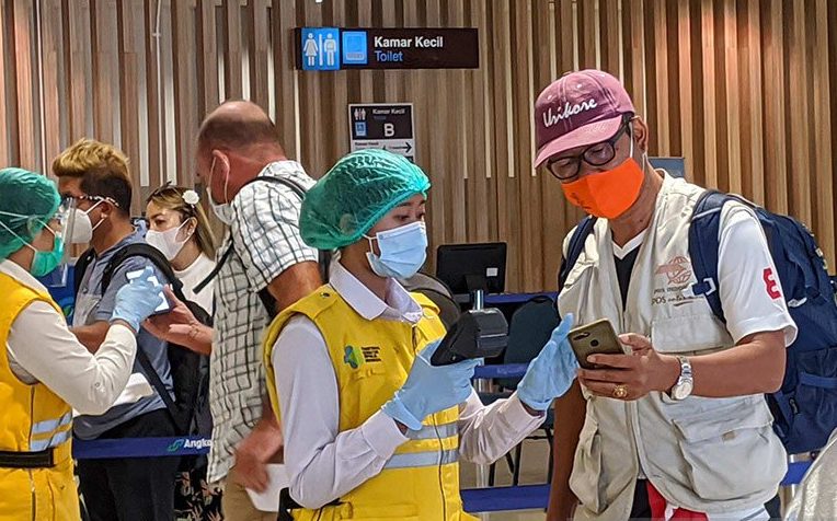 Petugas protokol kesehatan memindai barcode e-HAC (Health Alert Card) para pelancong di tengah wabah COVID-19 sebelum mengarah ke tempat pengambilan bagasi di bandara Ngurah Rai, Denpasar, Bali belum lama ini. (ANTARA/LINGKAR.CO)