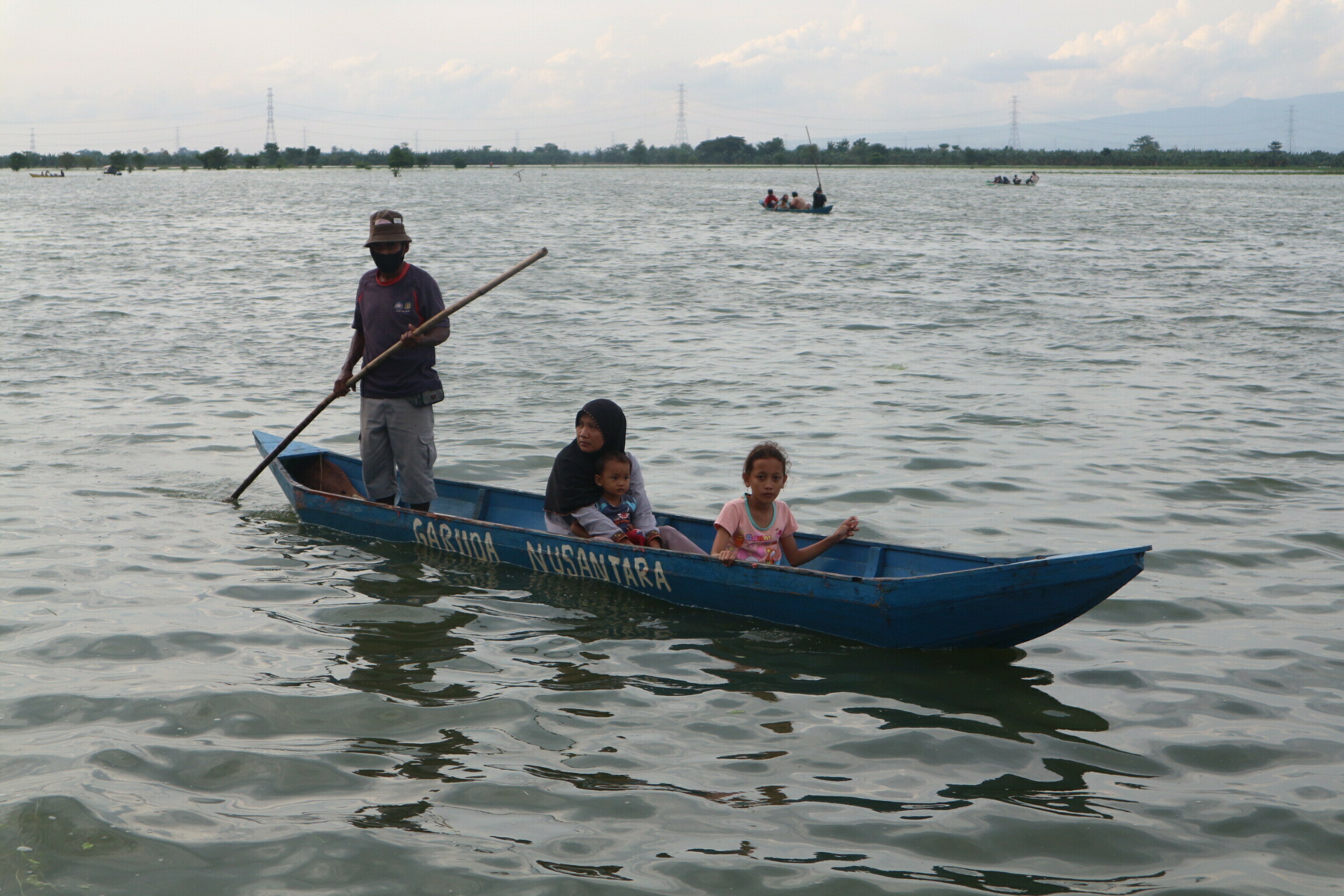 RAMAI: Pengunjung banjir di Desa Pasuruhan, Kecamatan Kayen sedang menaiki perahu untuk mengelilingi sawah yang terkena banjir, Senin (21/12). (FARIDHA NADHIRA/LINGKAR JATENG)