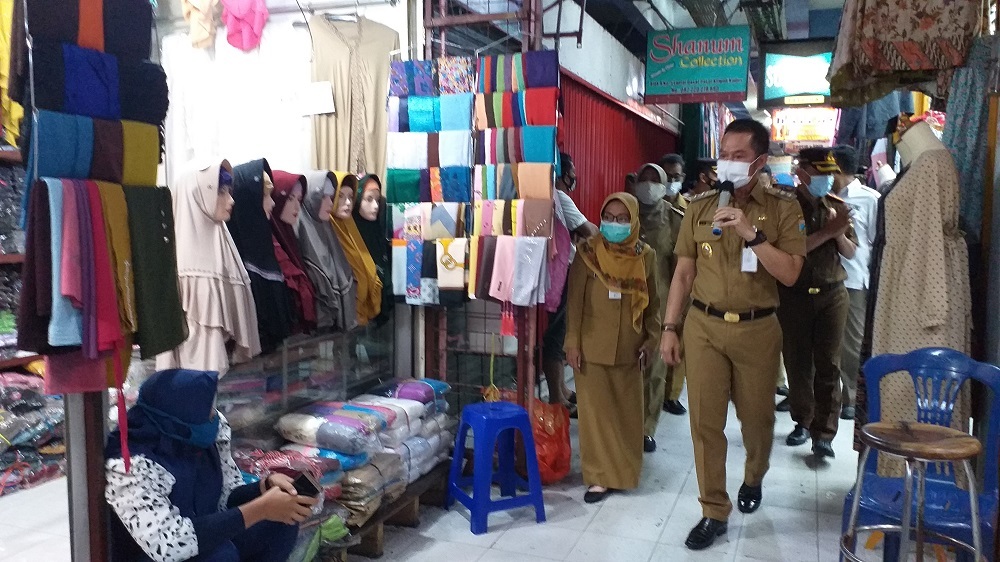Plt Bupati Kabupaten Kudus HM Hartopo saat mengingatkan para pedagang di pasar bitingan untuk menerapkan 3M, Senin (18/1). (NISA HAFIZHOTUS SYARIFA/LINGKAR.CO)