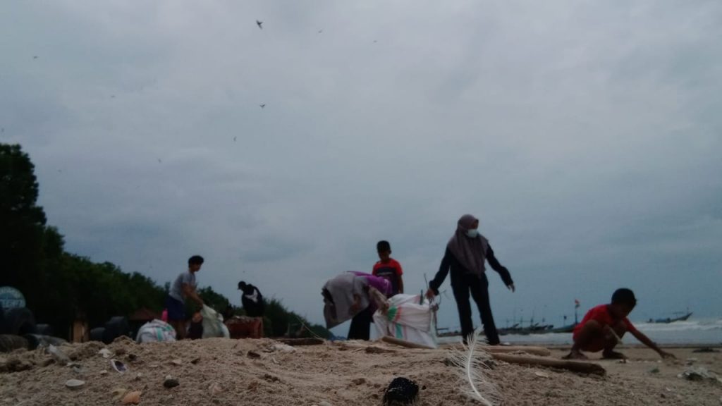 Sejumlah pemuda saat bahu-membahu membersihkan pantai dari sampah, Jum’at (22/1). (MIFTAHUS SALAM/LINGKAR.CO)