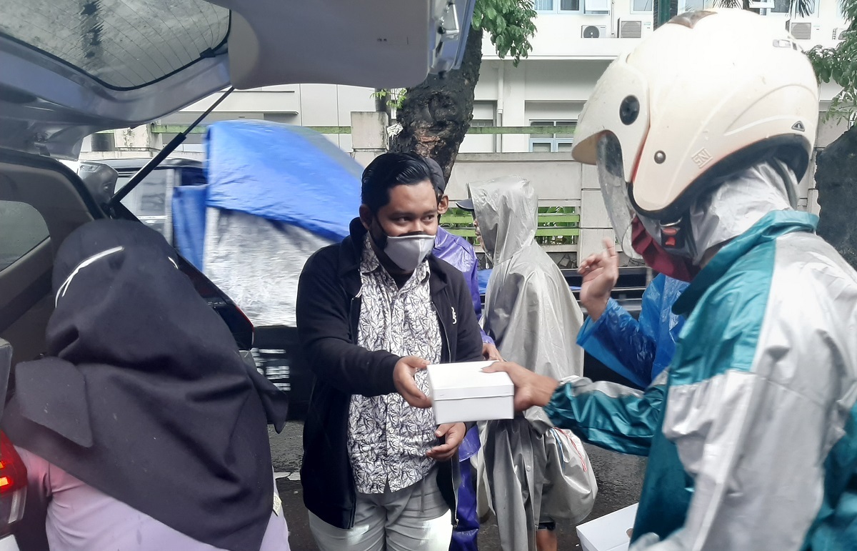 Direktur Online Lingkar.co Danny Lutvi Hidayat (masker abu-abu) saat membagikan nasi kotak ke tukang becak dan juru parkir di sekitar Pasar Bitingan Jumat (29/1/2021).(IVAN AJI/LINGKAR.CO)