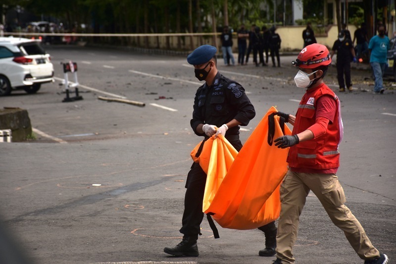 Petugas mengangkat kantong jenazah berisi bagian tubuh dari terduga pelaku bom bunuh diri di depan Gereja Katedral Makassar, Sulawesi Selatan, Minggu (28/3/2021).(ANTARA/LINGKAR JATENG)