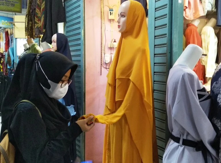 PILIH: Menjelang bulan ramadan, seorang pembeli sedang memilih baju di Pasar Kliwon Kudus.(ADITIA ARDIAN/LINGKAR.CO)