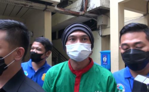 TERSANGKA: EAP alias Anji mengenakan baju tahanan berwarna hijau, didampingi oleh petugas penyidik menuju mobil untuk dibawa ke BNNP DKI Jakarta, Kamis (17/6). (ANTARA/LINGKAR.CO)