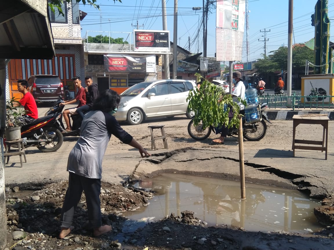 MENUNJUKKAN: Seorang warga menunjukkan lokasi semburan air dan lumpur yang ada di Kecamatan Wedarijaksa, Kabupaten Pati, Sabtu (24/7/21). (MIFTAHUS SALAM/LINGKAR.CO)