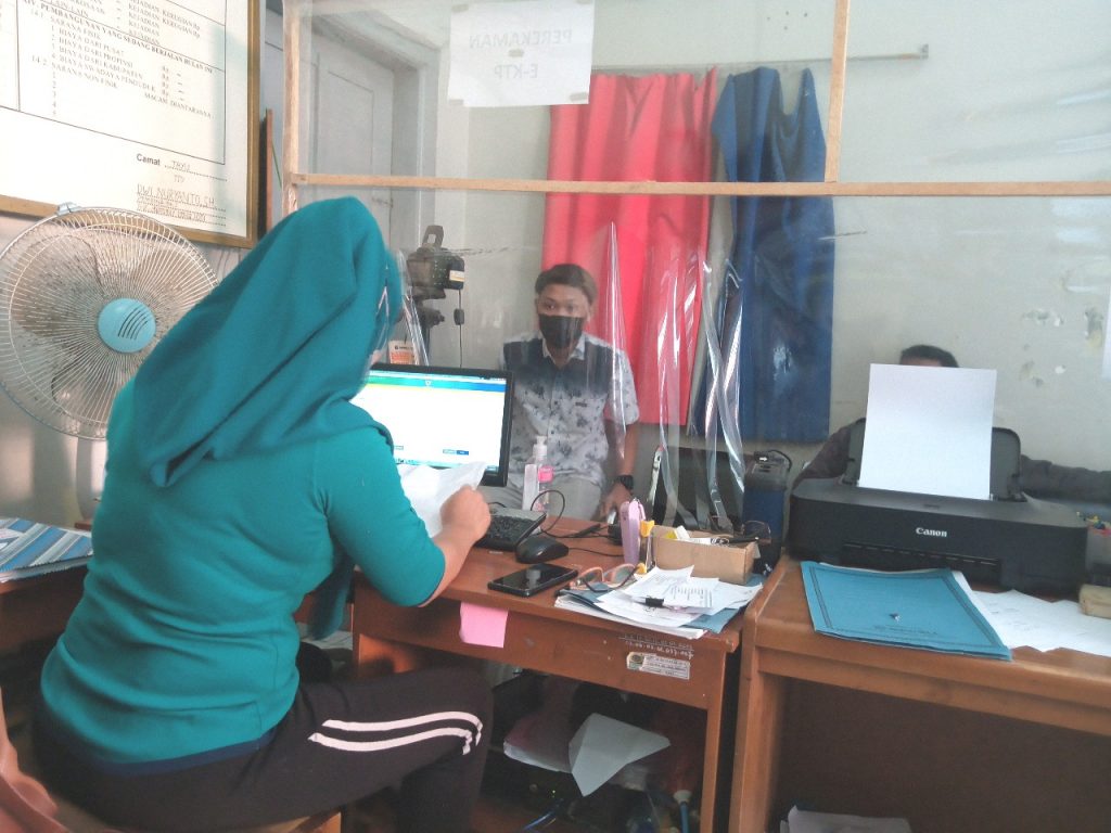 DUDUK: Petugas pelayanan berkas kependudukan Kantor Kecamatan Tayu sedang melayani masyarakat. (IBNU MUNTAHA/LINGKAR.CO)