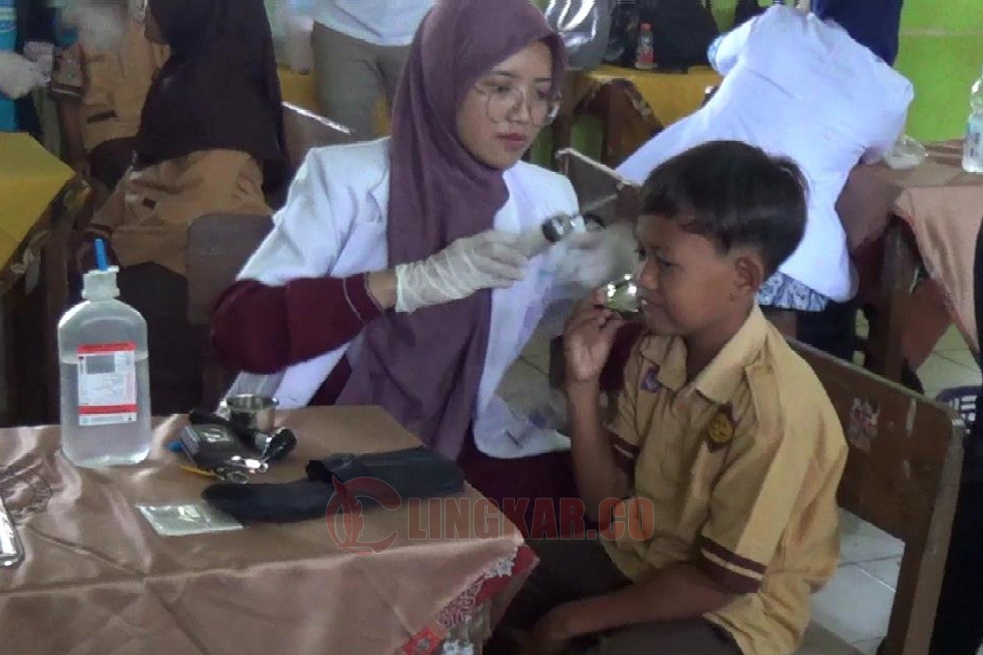 Salah satu dokter dari IDI Kabupaten Kendal saat memberikan pelayanan pembersihan telinga siswa SD Negeri 1 Pidodo Kulon, Kabupaten Kendal, Jawa Tengah, Jumat (23/5/2025). Foto: Wahyudi/Lingkar.co