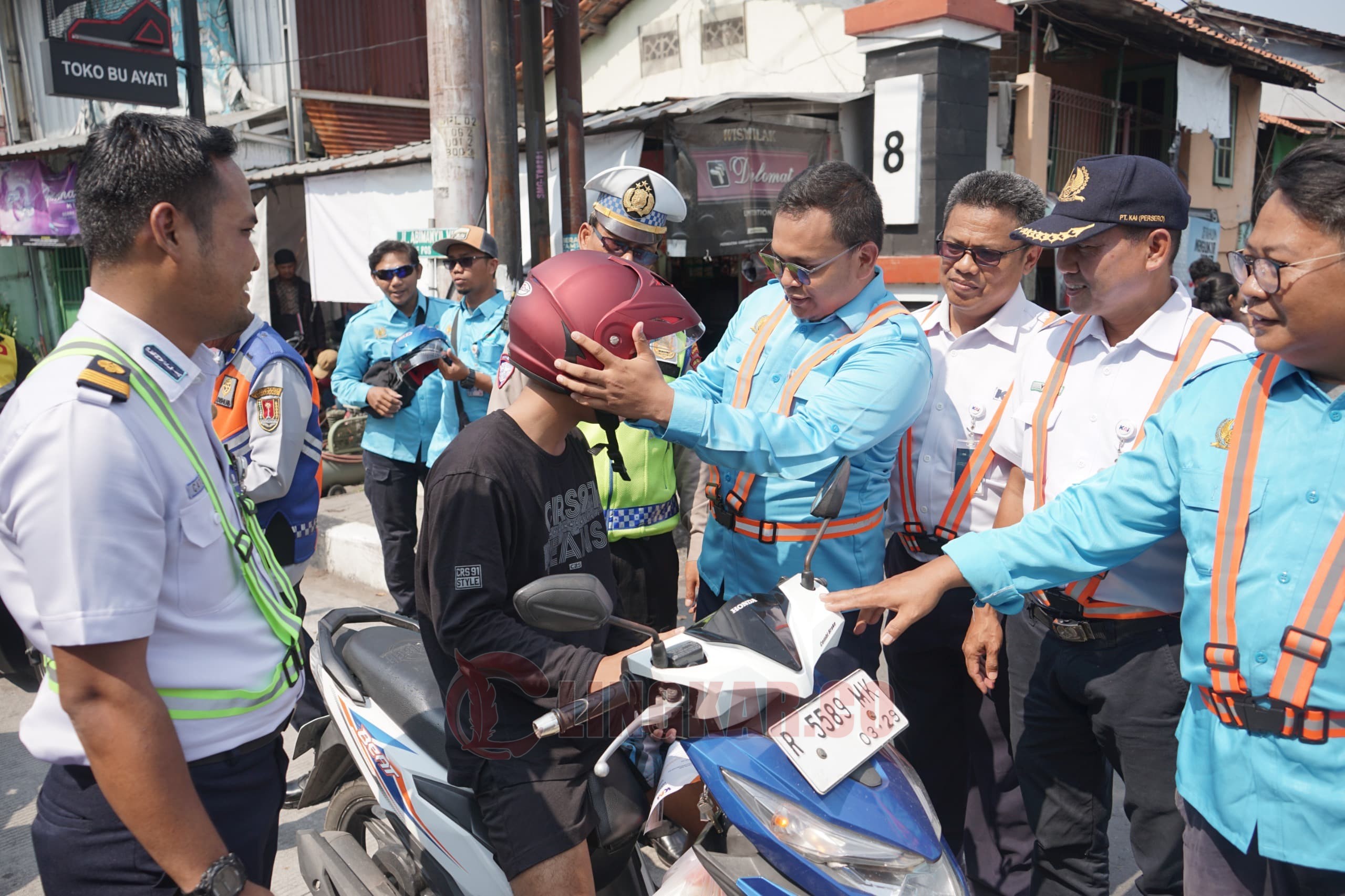 KAI bersama SPKA juga membagikan helm kepada para pengendara sepeda motor yang melintasi perlintasan sebidang. (dok KAI Daop 4 Semarang)