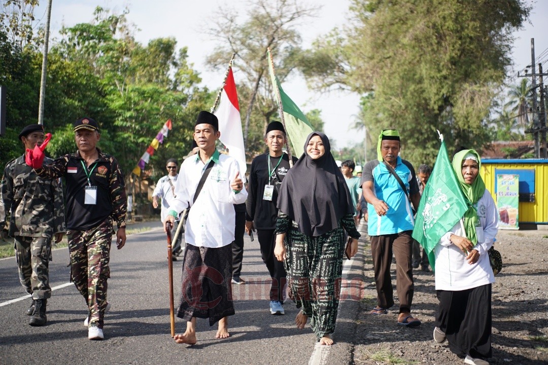 NADZAR JALAN KAKI. Warga NU Kecamatan Loano tampak berjalan kaki menunaikan nadzar sebagai bentuk syukur atas keberhasilannya membeli tanah dan membangun Gedung MWCNU secara swadaya. Foto: Lukman/Lingkar.co