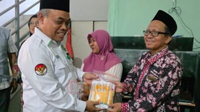 Kepala Kemenag Kota Semarang, Muhtasit beserta perwakilan Ditjen PHU Kemenag RI, dan BAZNAS RI serta perwakilan Baznas Kota Semarang menyerahkan dan haji 2025 kepada salah satu penerima. Foto: dokumentasi/istimewa