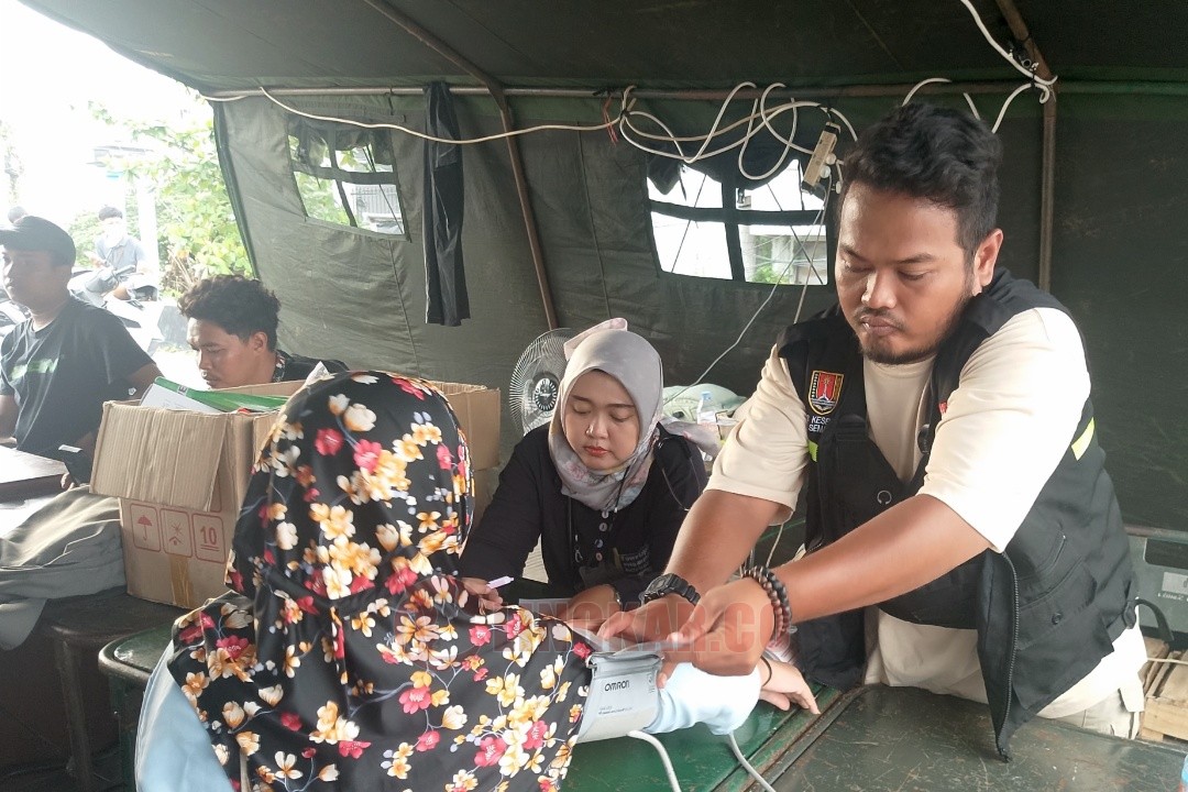 Petugas kesehatan dari Puskesmas Gayamsari saat melayani pasien di posko kesehatan yang didirikan di Jembatan Kaligawe Gayamsari, Kota Semarang, Rabu (29/10/2025) sore.