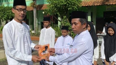 Guru pengampu saat menerima Butu Antologi Puisi 'Bingkai Santri' usai upacara peringatan HSN 2025 MTs Negeri 2 Purworejo. (dok Lukman Hakim)
