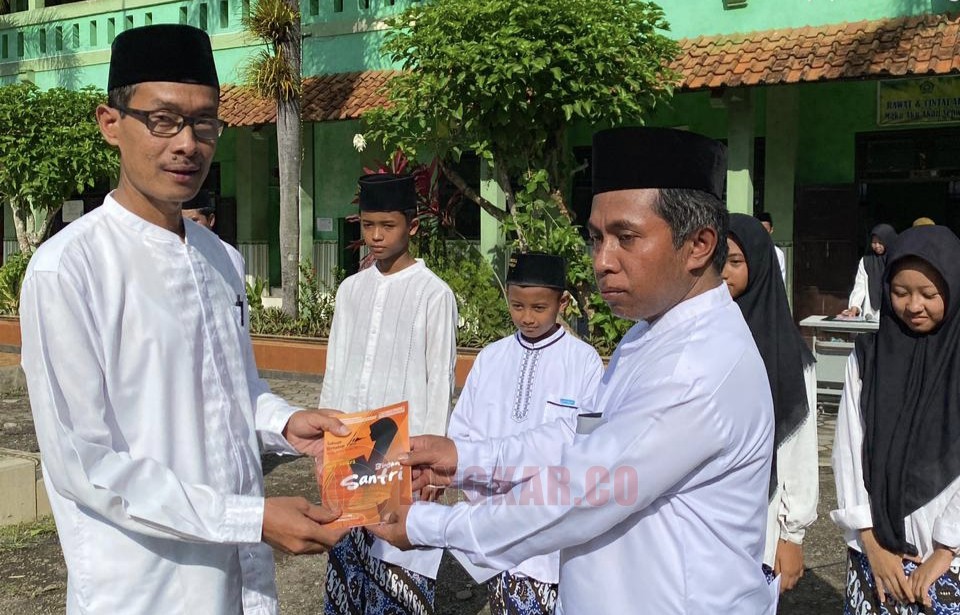 Guru pengampu saat menerima Butu Antologi Puisi 'Bingkai Santri' usai upacara peringatan HSN 2025 MTs Negeri 2 Purworejo. (dok Lukman Hakim)
