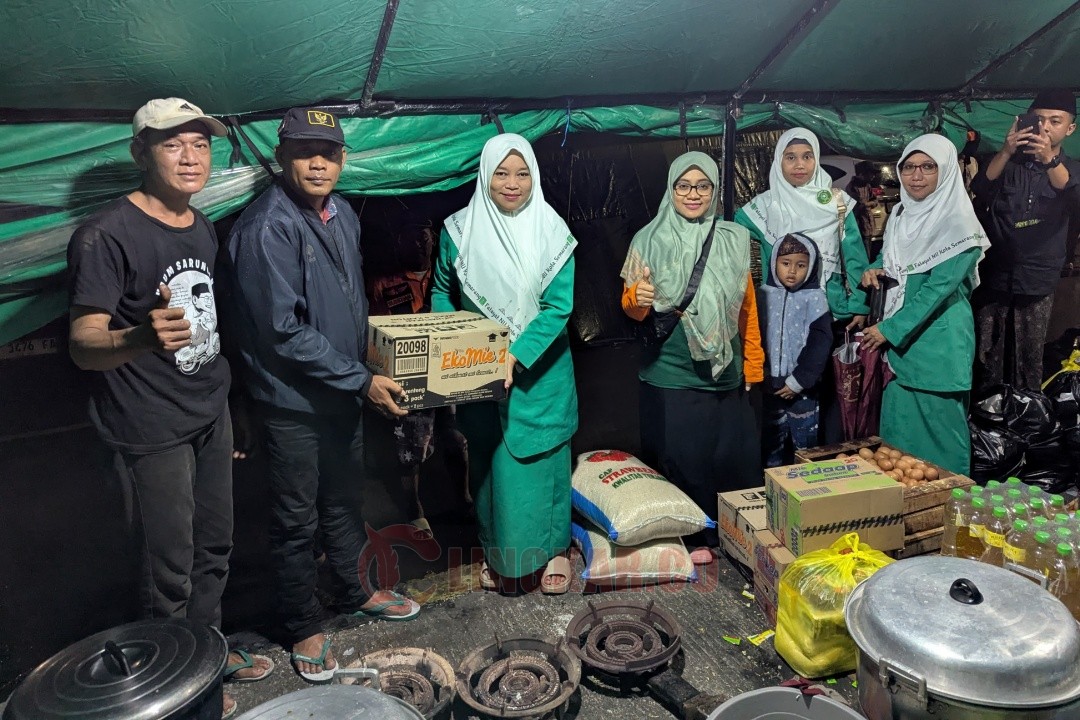 Aniqotun Nafiah bersama dengan beberapa pengurus PC Fatayat NU Kota Semarang saat menyerahkan bantuan secara simbolis kepada NU Peduli terdampak banjir di jembatan Kaligawe Semarang. Foto: dokumentasi/istimewa