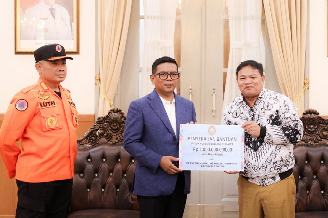 Ketua PGRI Provinsi Banten, Jamaluddin, menyerahkan bantuan kemanusiaan untuk Sumatra dan Aceh secara simbolis kepada Gubernur Banten Andra Soni di Gedung Negara Provinsi Banten, Kota Serang, Selasa (30/12/2025).