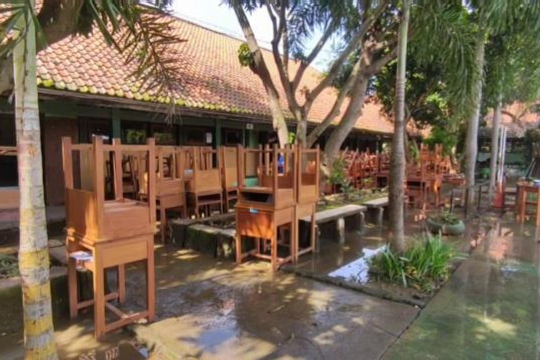 Meja dan kursi sekolah dikeluarkan dari ruang kelas yang sedang dibersihkan. Foto: istimewa