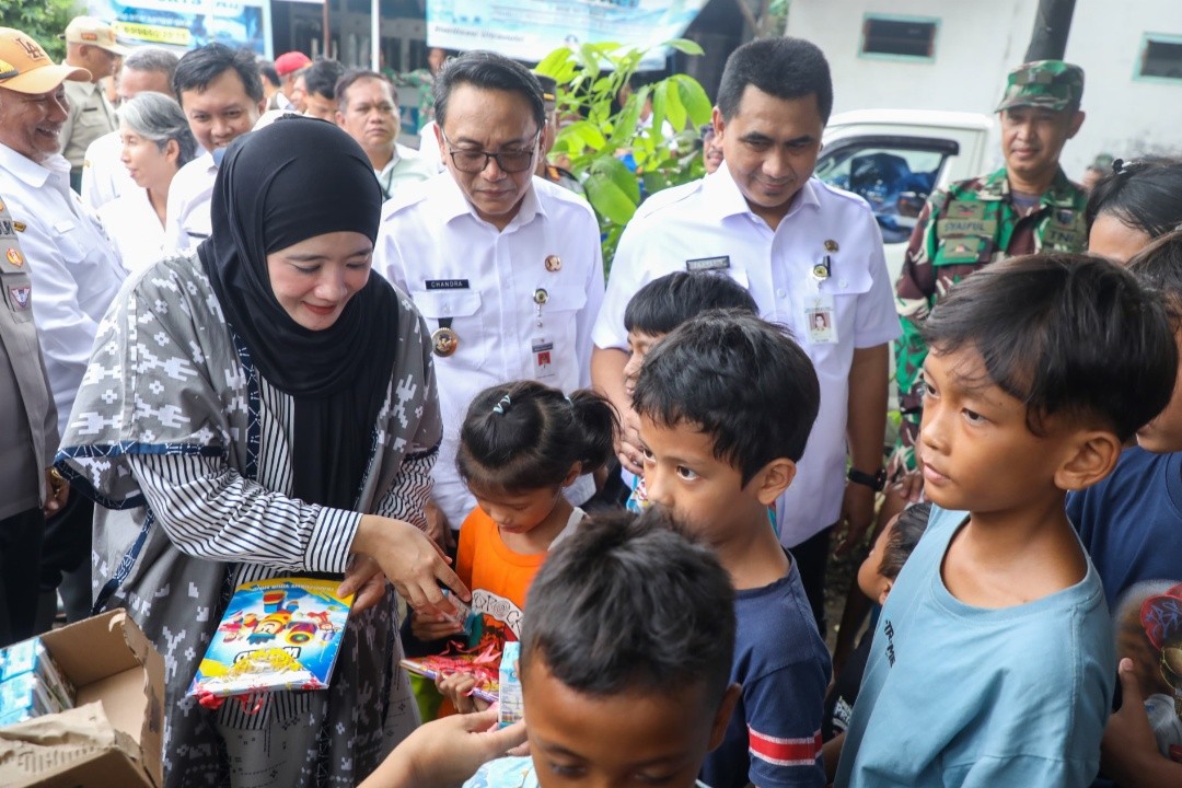 Ketua TP PKK Jawa Tengah, Nawal Arafah Yasin saat memberikan buku dan susu bagi anak-anak korban banjir di balai Desa Bumirejo dan Desa Doropayung kecamatan Juwana