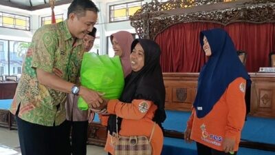 Sekretaris DLH Batang Muhammad Khuzaini menyerahkan bantuan dari Baznas secara simbolis kepada mustahik, Jumat (13/3/2026). Foto: dokumentasi