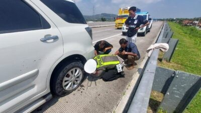 Personel Polres Kendal saat membantu ganti ban mobil pemudik di ruas Tol Batang–Semarang. Foto: dokumentasi