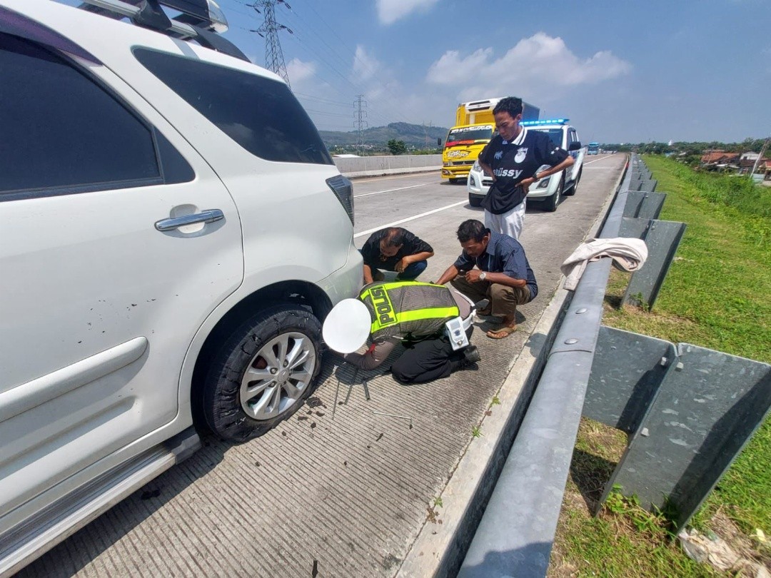 Personel Polres Kendal saat membantu ganti ban mobil pemudik di ruas Tol Batang–Semarang. Foto: dokumentasi