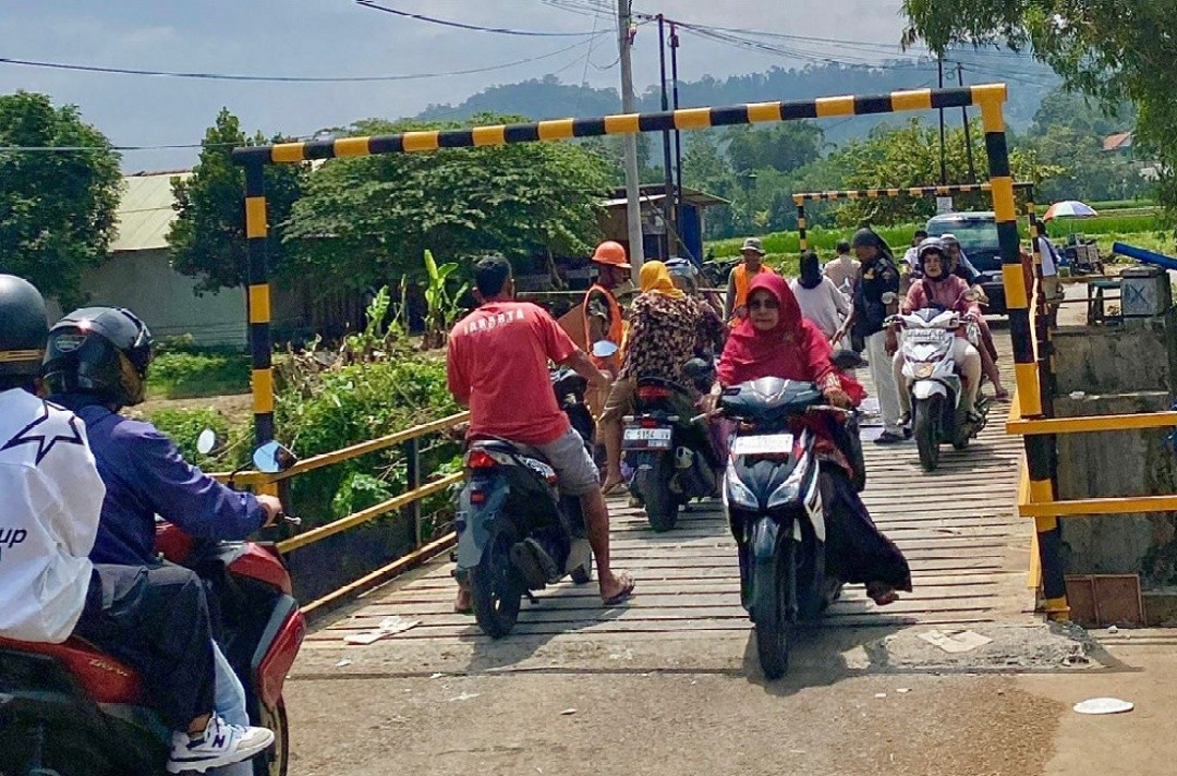 Pengendara sepeda motor saat melintas kembali di Jembatan Kalibelo, Kabupaten Batang usai diperbaiki. Foto: dokumentasi/istimewa